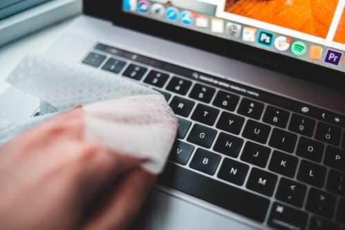 A virtual assistant cleans their laptop